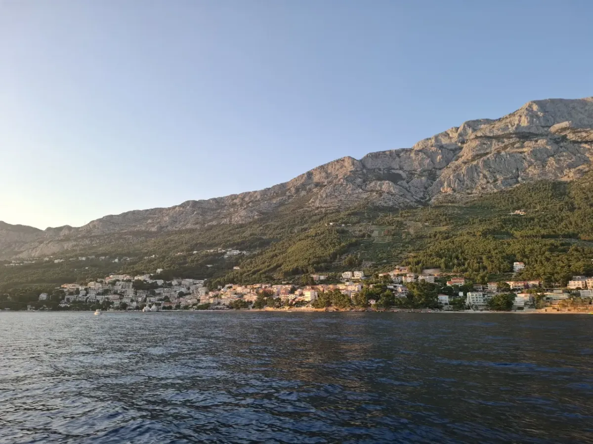 Brela waterfront and the Biokovo mountain glowing in the evening light, seen from the sea